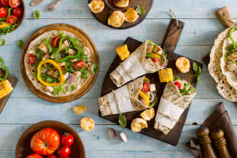 Roll tortilla with grilled chicken fillet on wooden cutting boar 613689564 1257x838