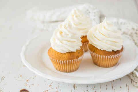 Vanilla cupcakes on white wood background 525969168 1258x838