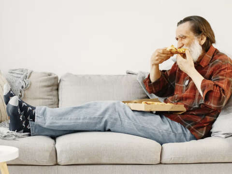 Older man eating pizza